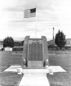 A front view of the original 1943 Servicemembers Monument with two eagle statues and two flower planters in Main Street Park. (Post card donated by Scott St. Clair.)