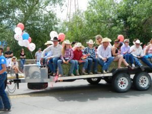 East Helena Valley Rodeo Parade, parade float with hay bales and rodeo volunteers.