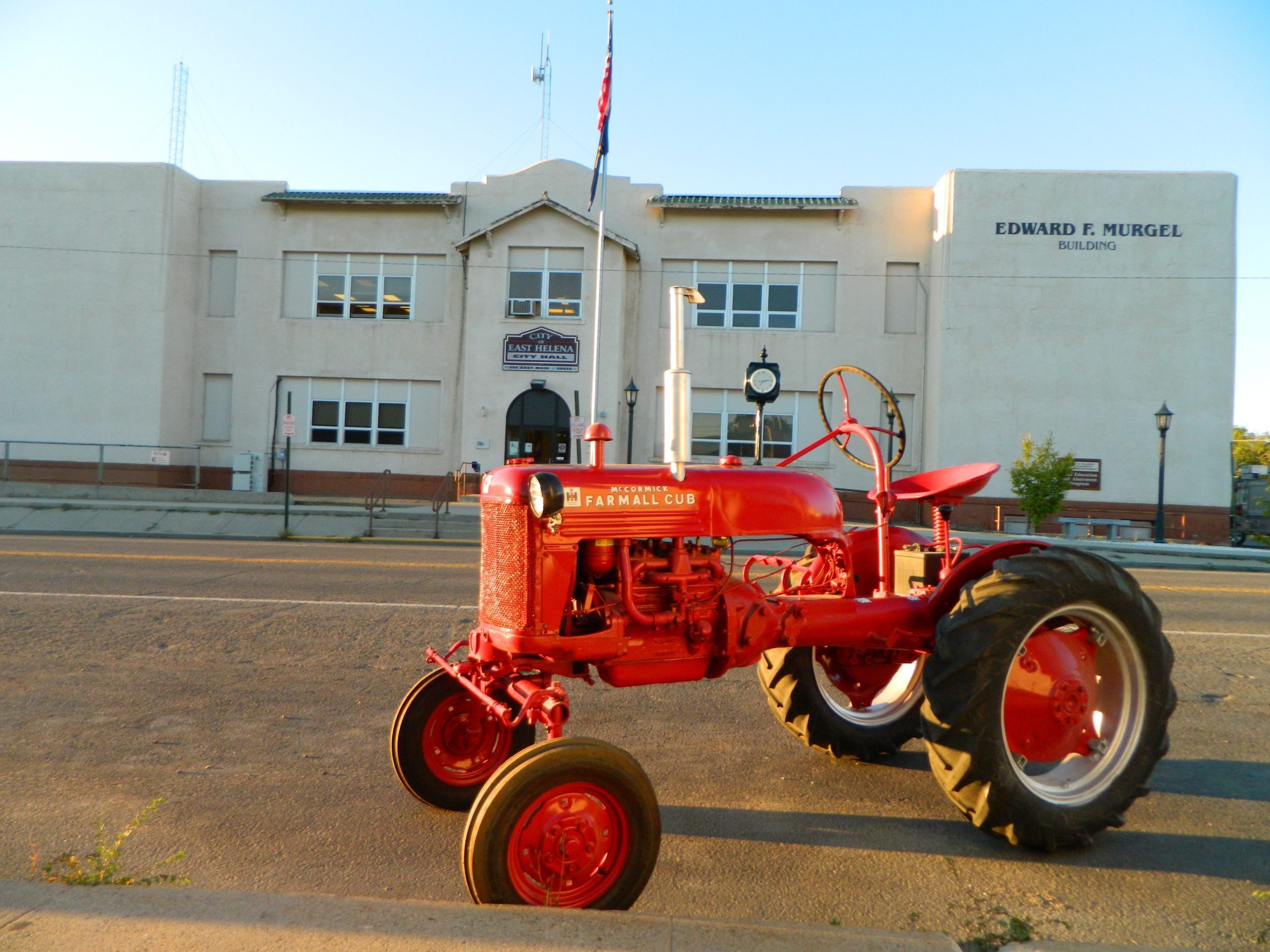 East Helena City Hall with an antique red tractor with a beautiful blue sky.
